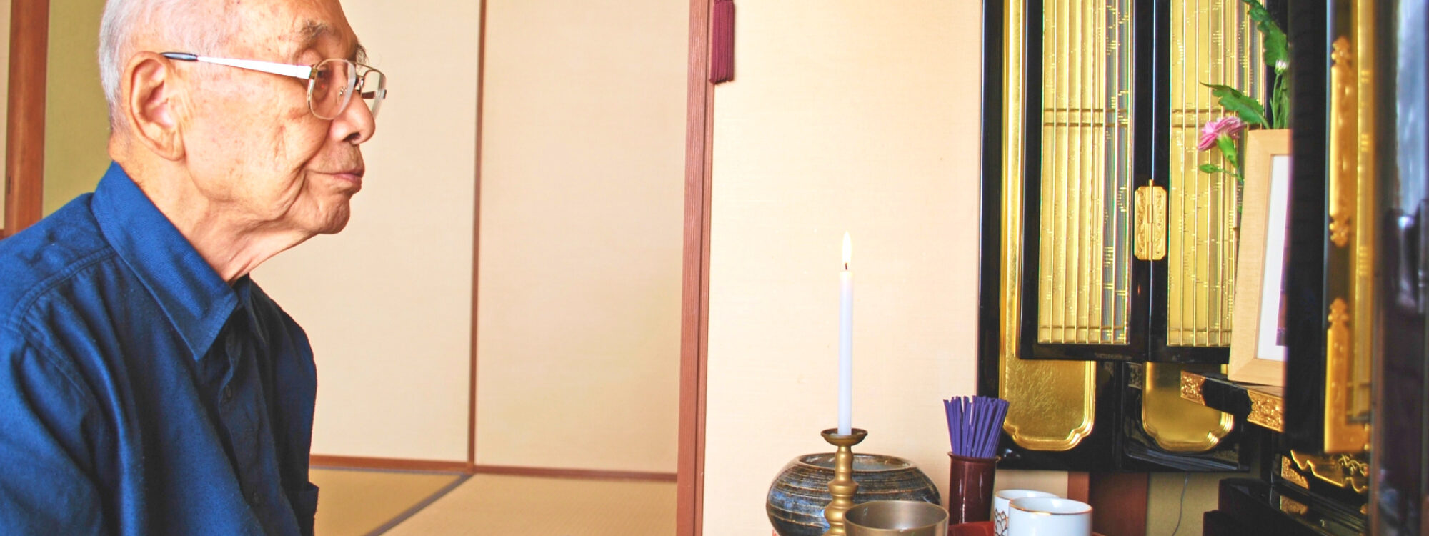 An old man worshipping at a Buddhist altar